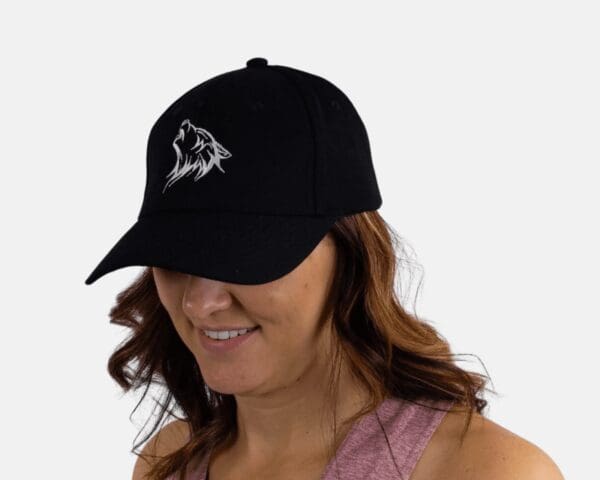 A woman wearing a black hat with a mountain on it.