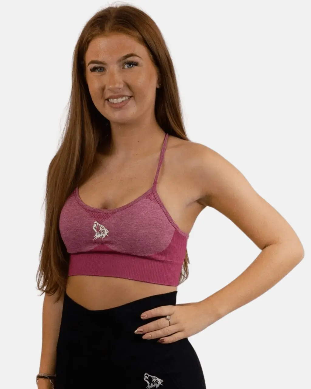 A woman wearing a pink sports bra posing for the camera.