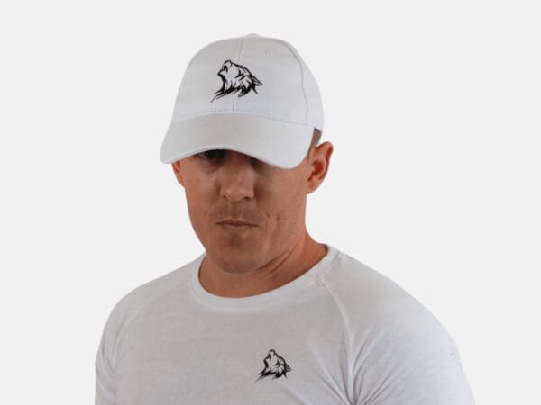 A man wearing a white hat with an animal on it.