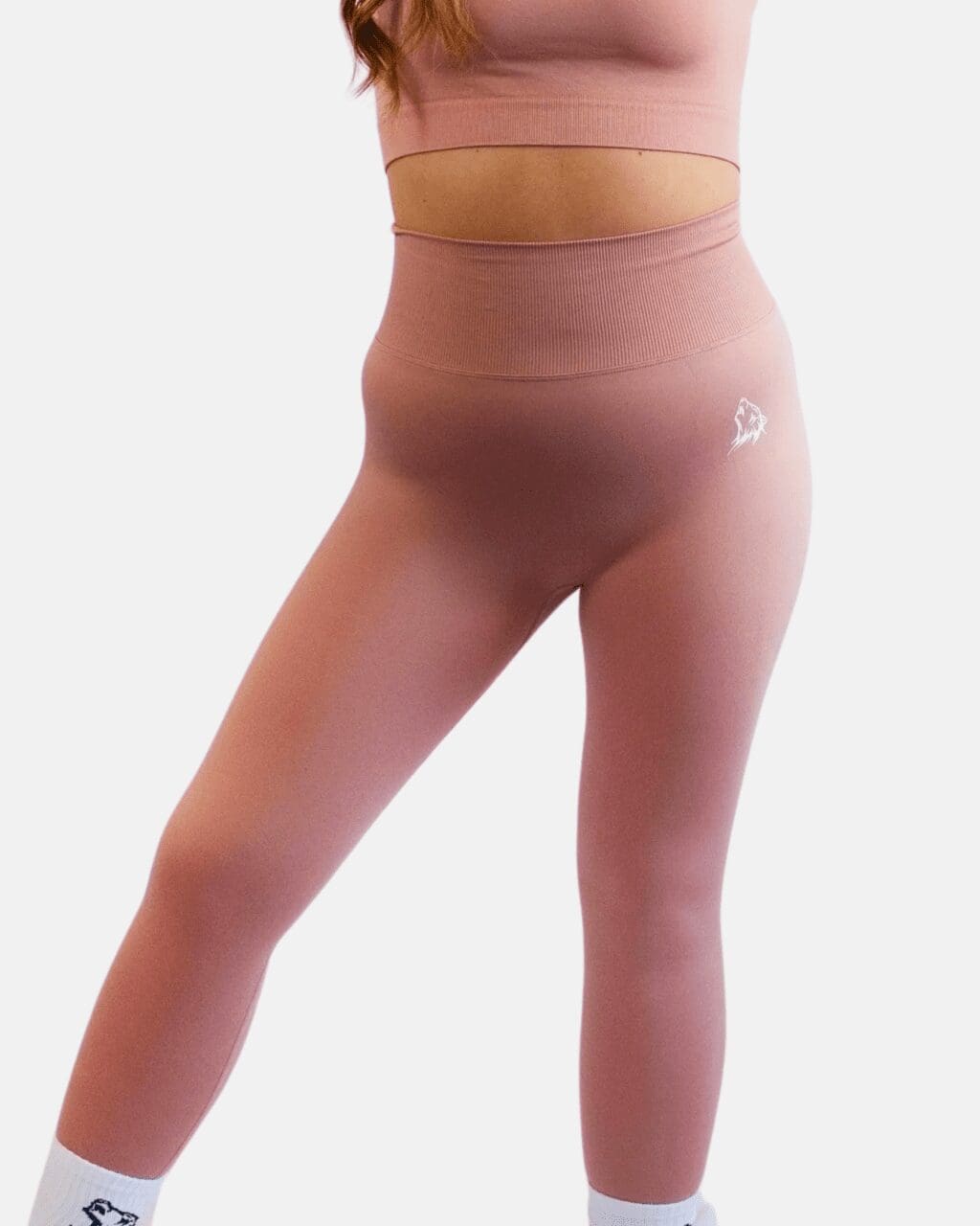 A woman wearing pink leggings and a bra