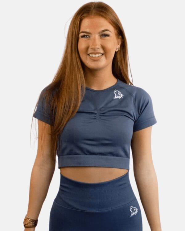 A woman wearing a blue crop top and leggings.