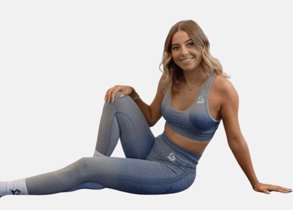 A woman sitting on the ground wearing a blue outfit.