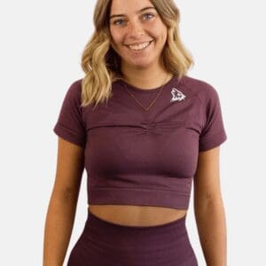 A woman wearing a purple crop top and leggings.