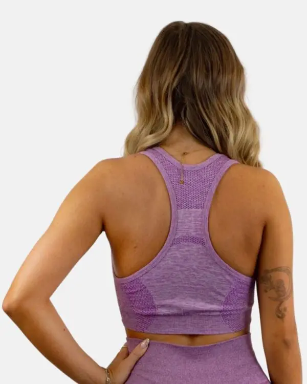 A woman wearing a purple sports bra and shorts.