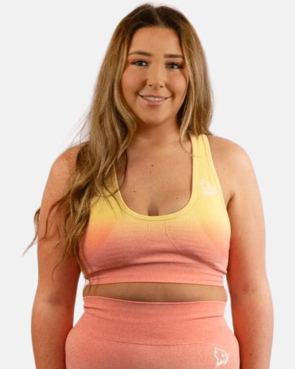 A woman wearing a pink and yellow sports bra.