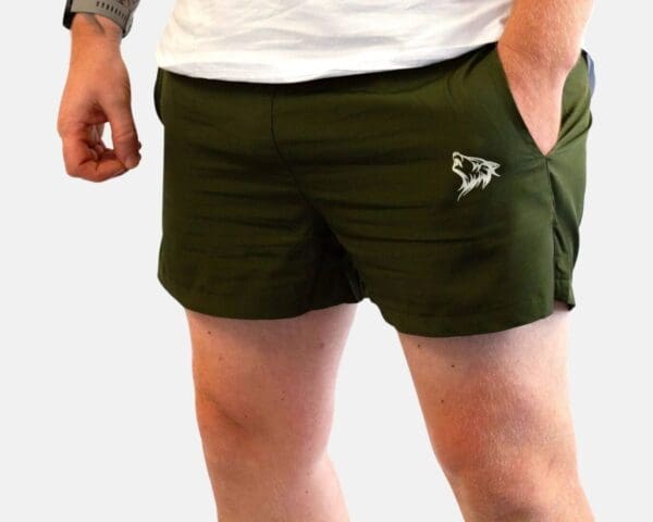 A man wearing green shorts with an animal on the side.