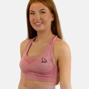 A woman wearing a pink sports bra and leggings.