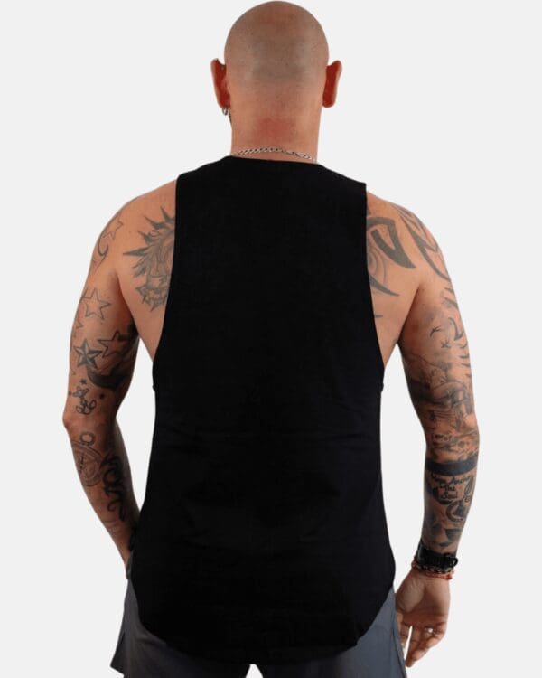 A man with tattoos is standing in front of the camera.