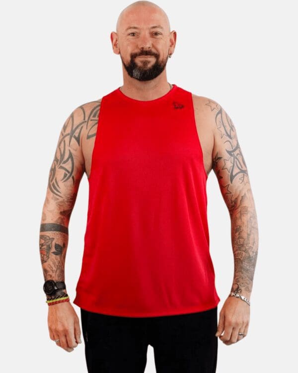 A man with tattoos wearing red tank top.