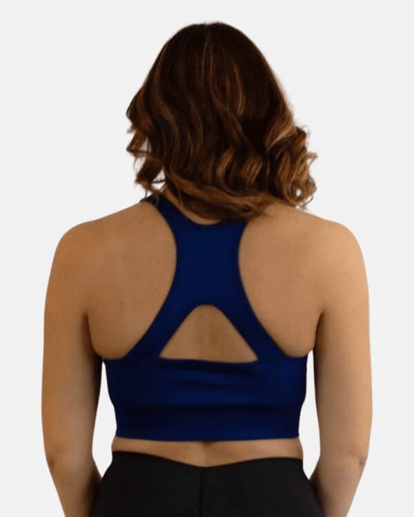 A woman wearing a blue sports bra with an open back.