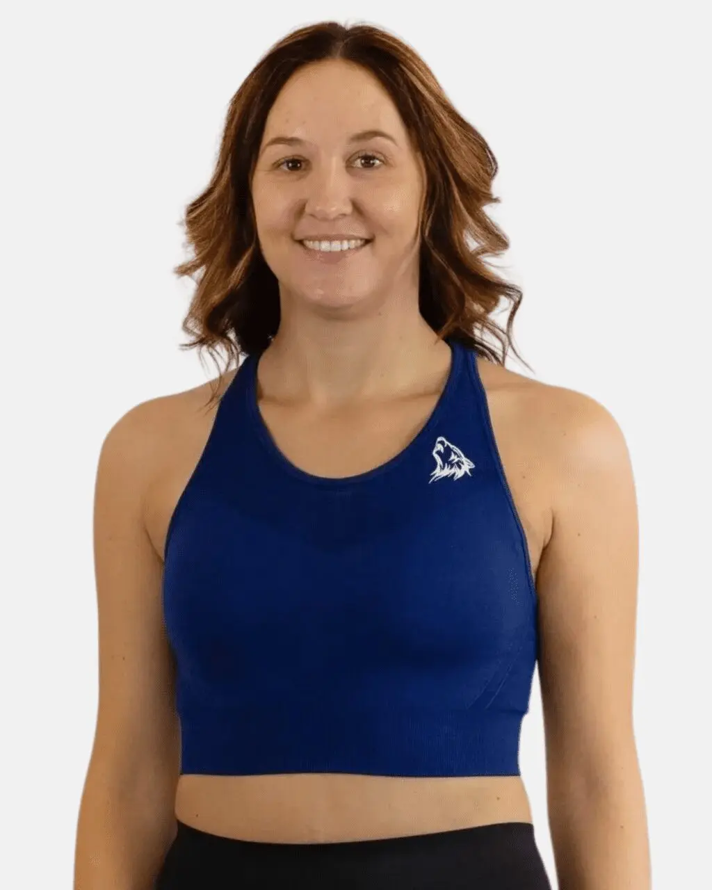 A woman wearing a blue sports bra smiling.
