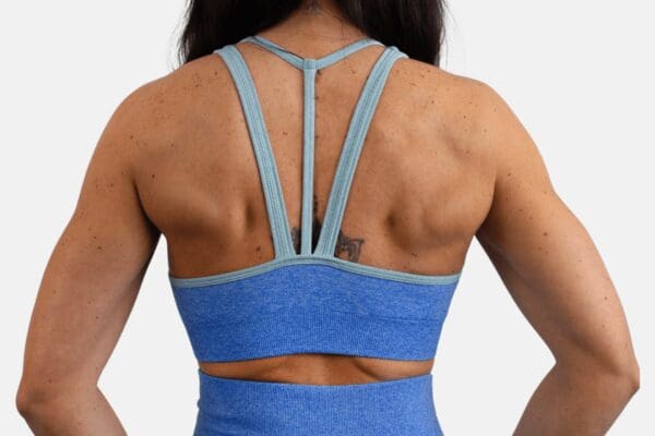 A woman is seen from the back wearing a blue sports bra.