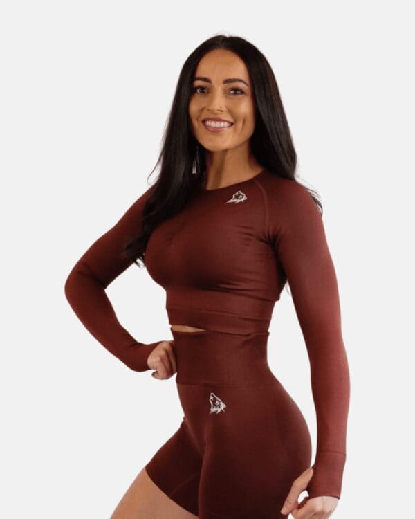 A woman in maroon long sleeve top and leggings.