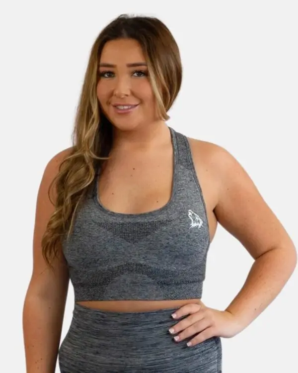 A woman wearing a gray sports bra and black pants.