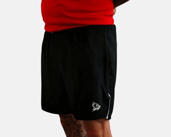 A man wearing black shorts and red shirt.