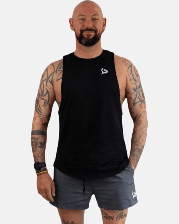 A man with tattoos and glasses wearing a black tank top.