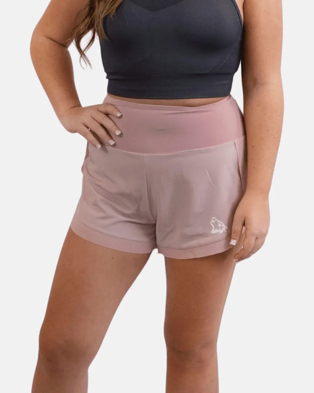 A woman wearing pink shorts and black top.