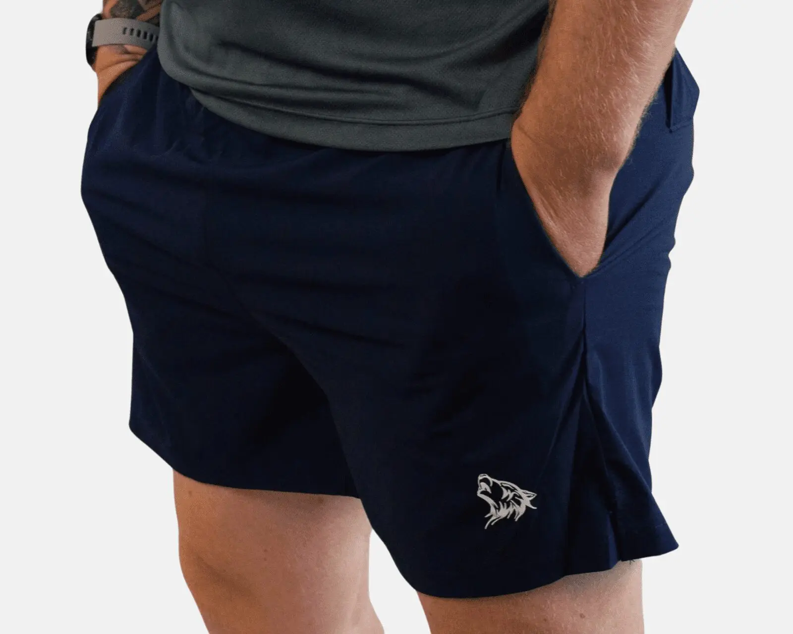 A man wearing dark blue shorts with an animal on the side.