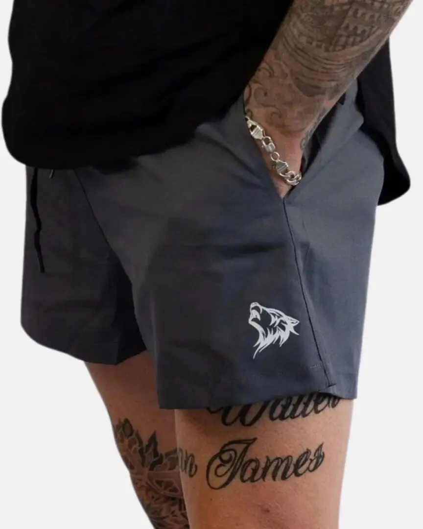 A person wearing grey shorts with a wolf on the side.