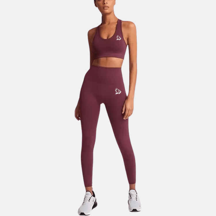 Woman wearing maroon workout leggings and top.